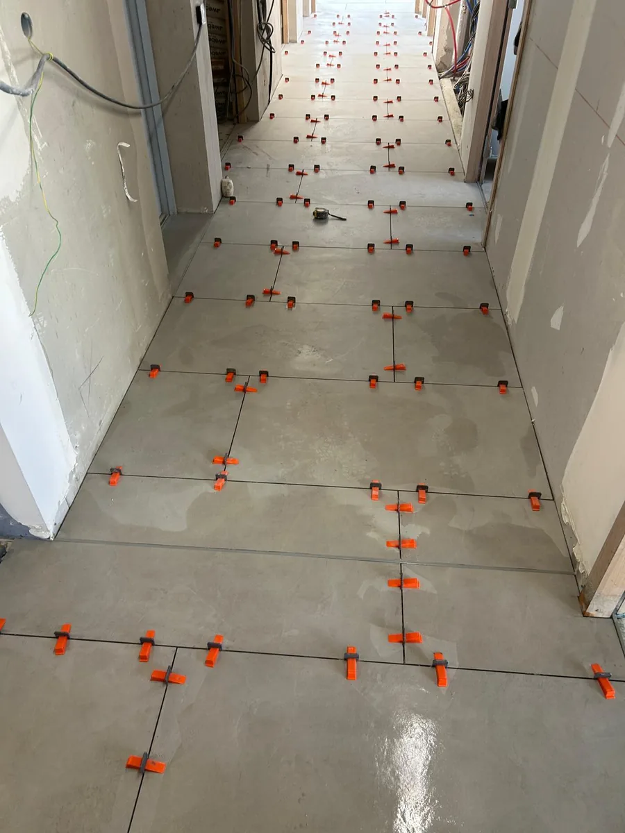 Pose de carrelage grand format dans un couloir
