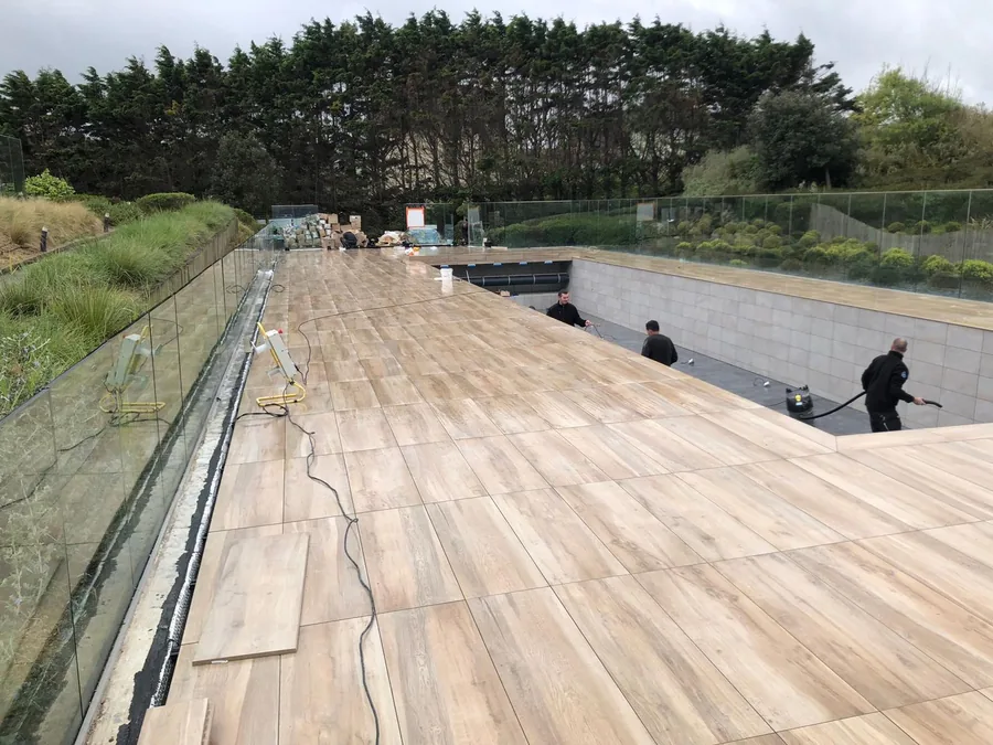 Chantier de terrasse carrelée autour d’une piscine